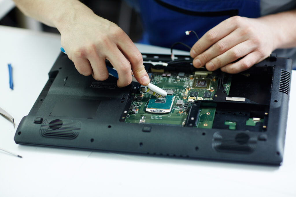 Computer repair and upgrade technician servicing laptop hardware and internal components